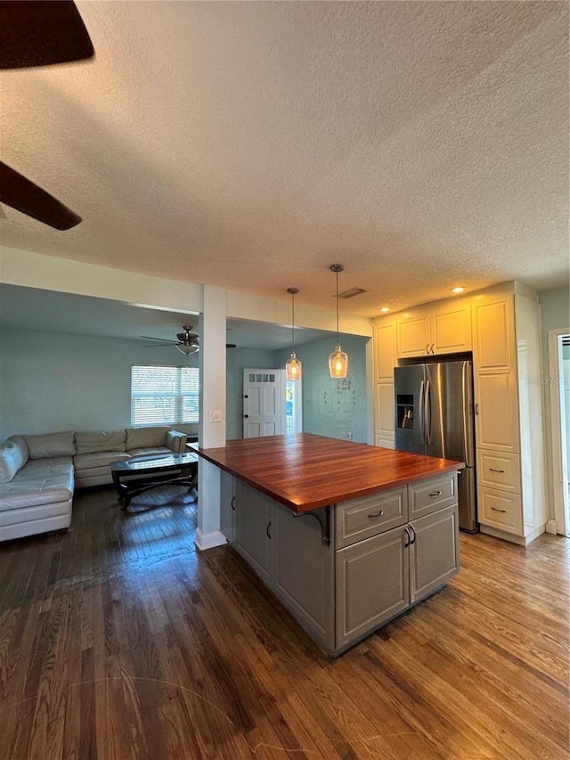 kitchen featuring dark wood-style flooring, open floor plan, wood counters, and stainless steel fridge with ice dispenser