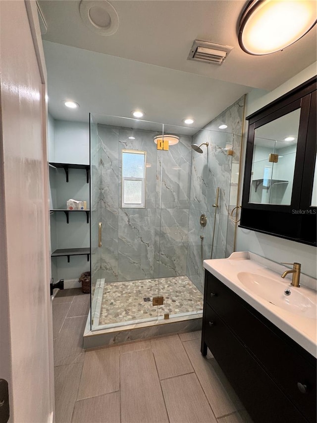 full bath with recessed lighting, a marble finish shower, visible vents, and vanity