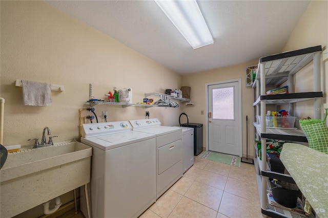 laundry room with a sink, laundry area, light tile patterned flooring, and washing machine and dryer