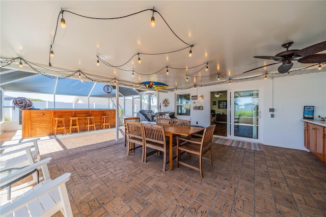 dining space with a ceiling fan and a sunroom