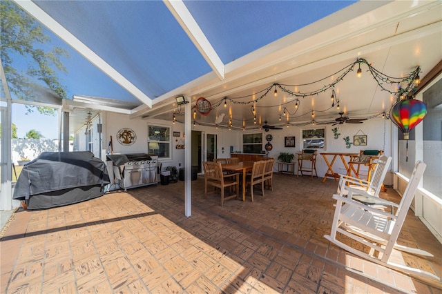 view of patio / terrace featuring ceiling fan, glass enclosure, outdoor dining space, and a grill