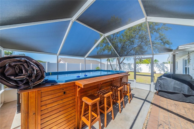 view of patio with a fenced backyard, a lanai, a grill, outdoor dry bar, and a swimming pool