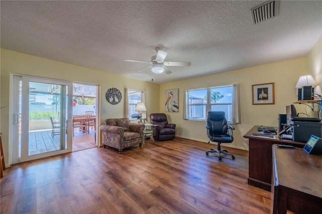 home office featuring ceiling fan, visible vents, plenty of natural light, and wood finished floors