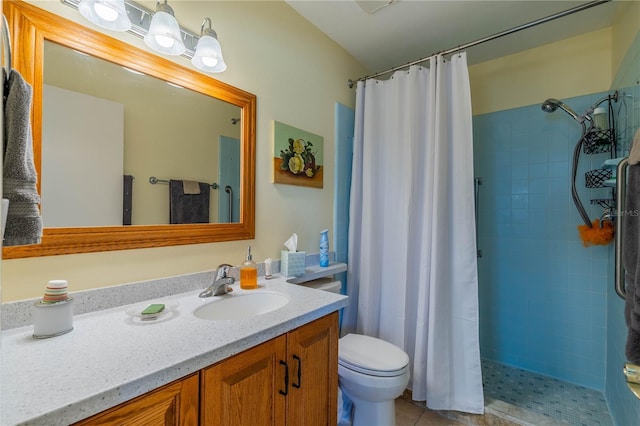 full bathroom featuring toilet, a tile shower, and vanity