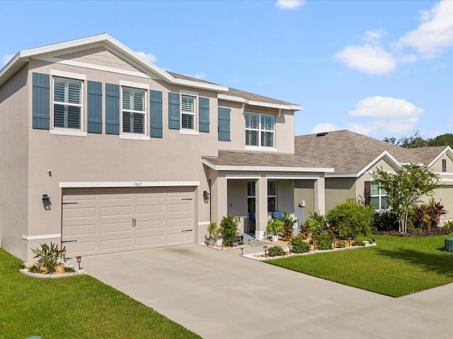 view of front of house featuring driveway, a front yard, and stucco siding