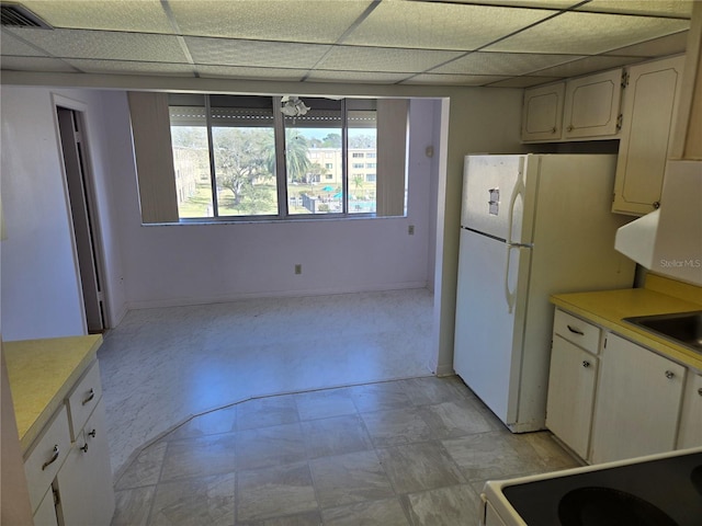 kitchen with visible vents, freestanding refrigerator, light countertops, a paneled ceiling, and stove