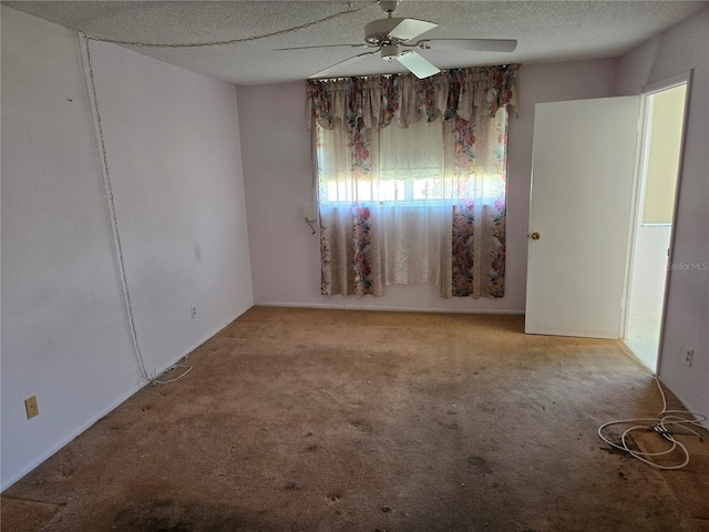 carpeted spare room with a textured ceiling and ceiling fan