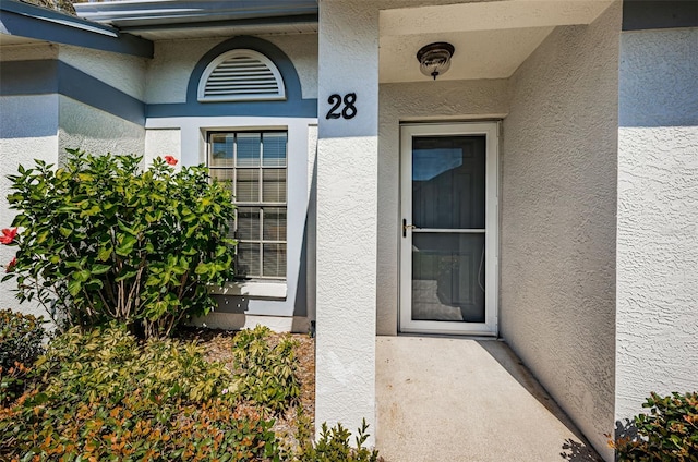 entrance to property with stucco siding