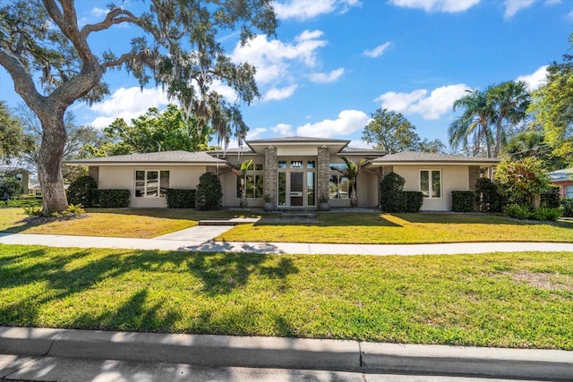 view of front of property with stucco siding and a front lawn