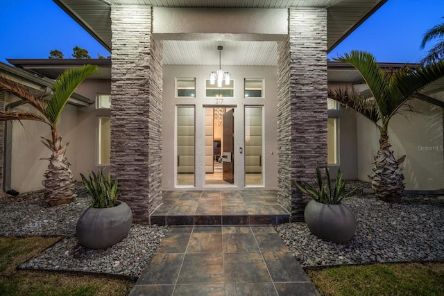 doorway to property featuring stucco siding