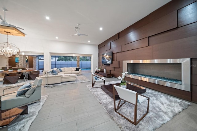 living area featuring recessed lighting and ceiling fan with notable chandelier