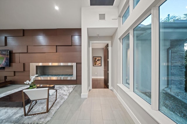 living room featuring a fireplace, baseboards, and visible vents