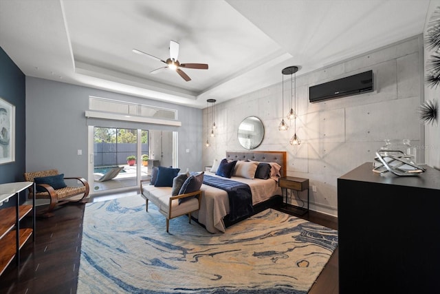 bedroom featuring a raised ceiling, access to outside, wood finished floors, and ceiling fan