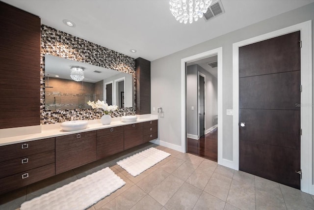 bathroom featuring vanity, visible vents, a tile shower, tile patterned floors, and a notable chandelier