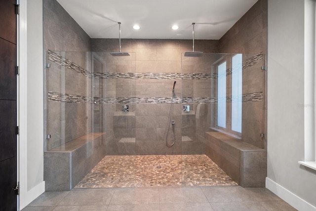 full bathroom featuring tile patterned flooring, tiled shower, and baseboards