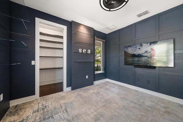 interior space with visible vents, a decorative wall, and wood finished floors