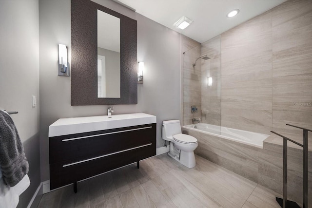 full bath with vanity, toilet, baseboards, and tiled shower / bath combo