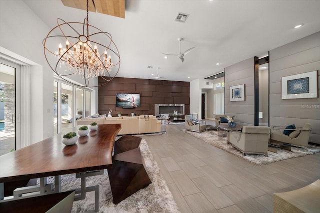 dining space featuring visible vents, an accent wall, wood finish floors, recessed lighting, and an inviting chandelier