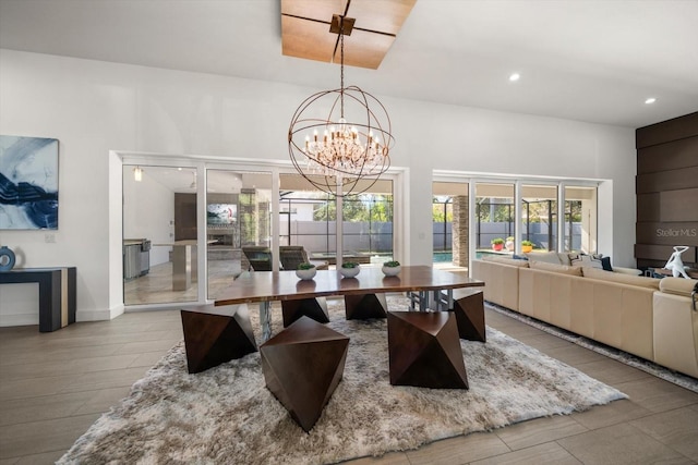 dining space featuring recessed lighting, a healthy amount of sunlight, a chandelier, and a towering ceiling