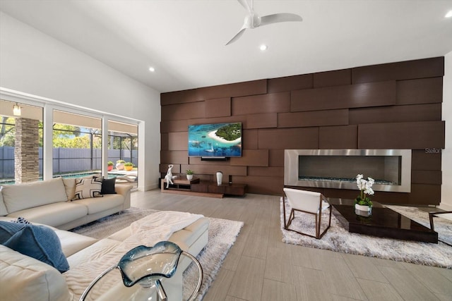 living area featuring an accent wall, recessed lighting, wood finished floors, and ceiling fan