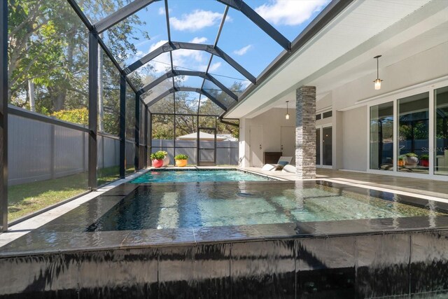 view of pool featuring glass enclosure, a patio, a fenced backyard, and a fenced in pool