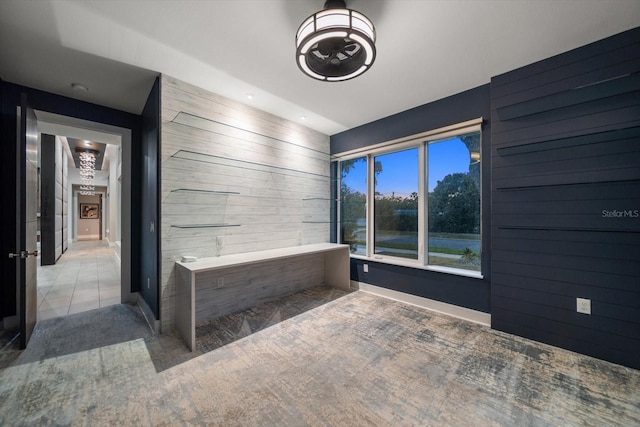 bathroom with tile patterned floors and wood walls