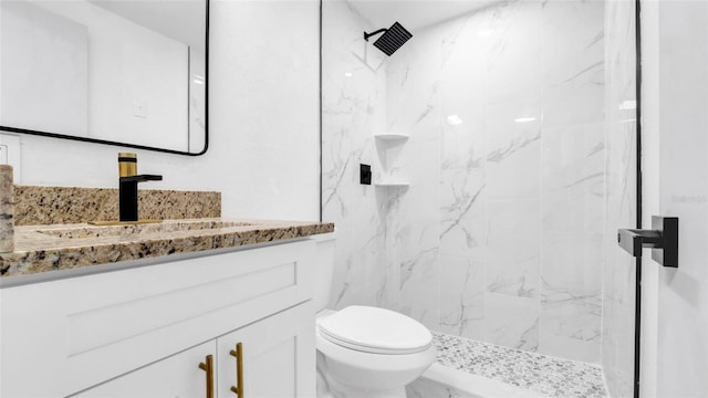 full bath with toilet, marble finish floor, a marble finish shower, and vanity