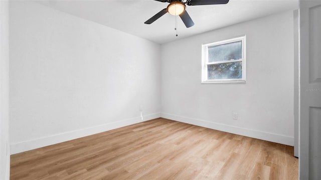 spare room with light wood-style floors, ceiling fan, and baseboards