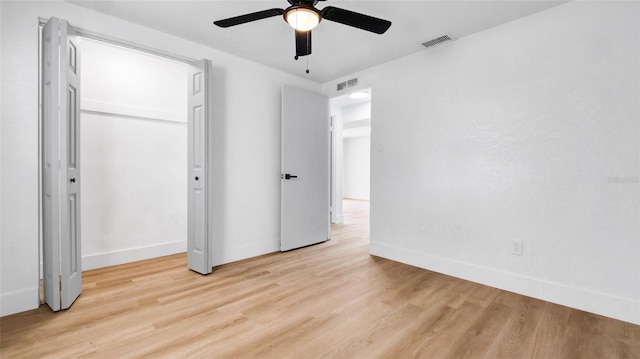 unfurnished bedroom featuring ceiling fan, light wood-style flooring, visible vents, and baseboards