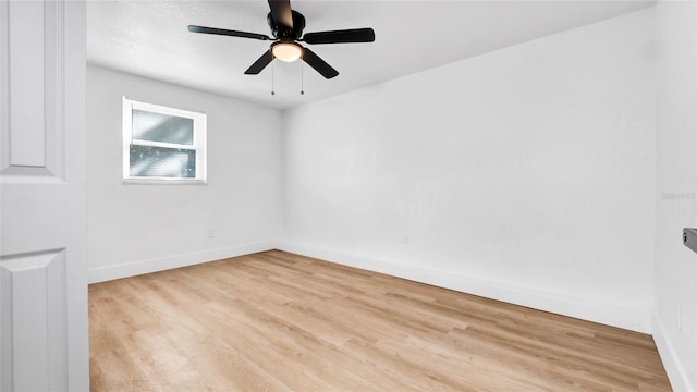 spare room with ceiling fan, baseboards, and wood finished floors