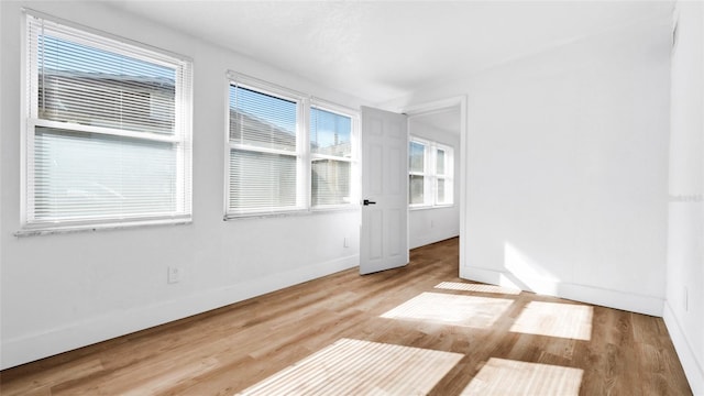 empty room with baseboards and wood finished floors