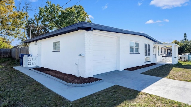 view of property exterior with a garage, fence, a pergola, and stucco siding