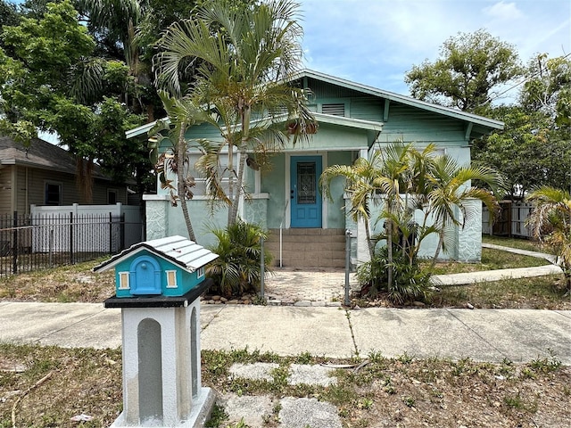 bungalow-style house featuring covered porch and fence