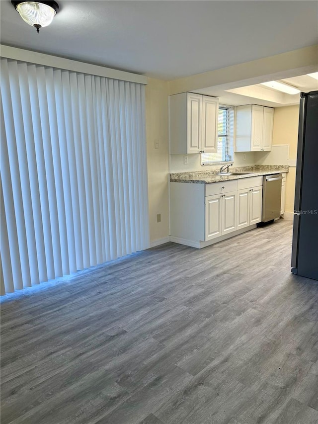 kitchen with white cabinets, a sink, stainless steel appliances, and wood finished floors