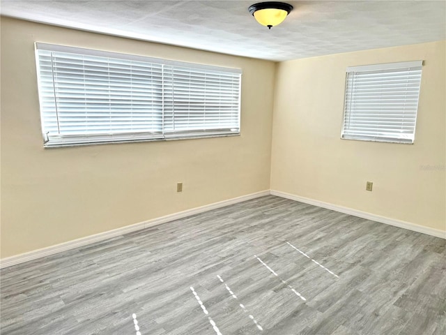 empty room featuring baseboards and wood finished floors