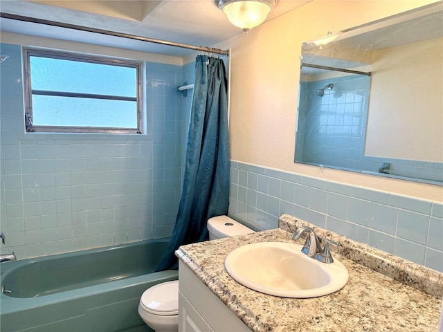 bathroom featuring toilet, a wainscoted wall, shower / tub combo, vanity, and tile walls