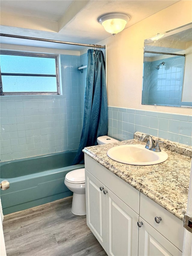 full bath with decorative backsplash, shower / bath combo with shower curtain, toilet, vanity, and wood finished floors