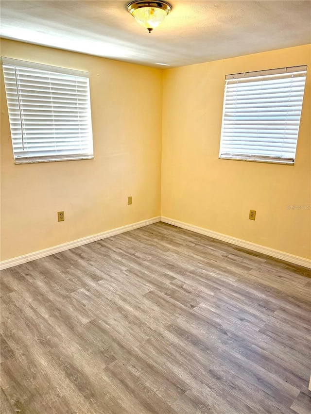 empty room with wood finished floors and baseboards