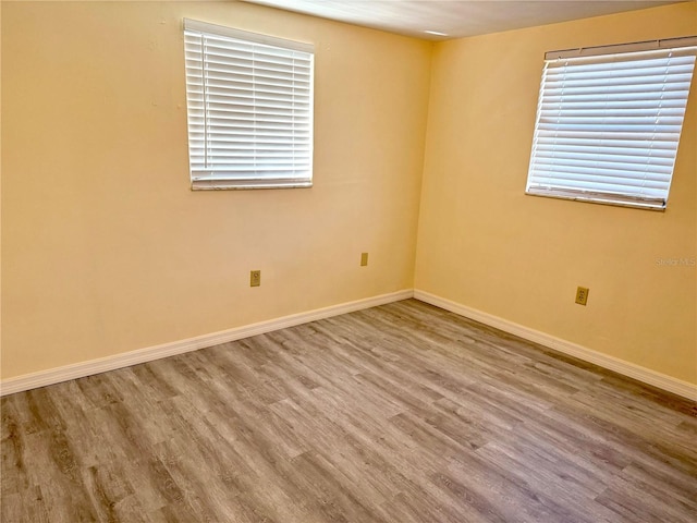 unfurnished room with wood finished floors and baseboards