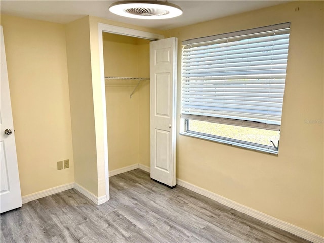 unfurnished bedroom featuring a closet, visible vents, light wood-style flooring, and baseboards