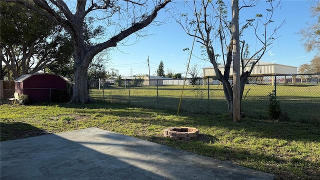 view of yard with a fire pit, a patio, and fence