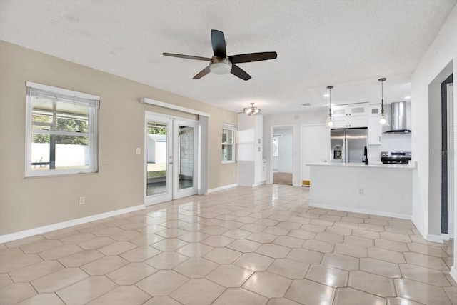 unfurnished living room with french doors, a textured ceiling, and baseboards