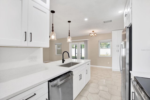 kitchen with appliances with stainless steel finishes, white cabinets, a sink, and french doors