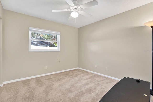 spare room featuring carpet, baseboards, and a ceiling fan