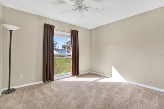 carpeted empty room with a textured ceiling, ceiling fan, and baseboards