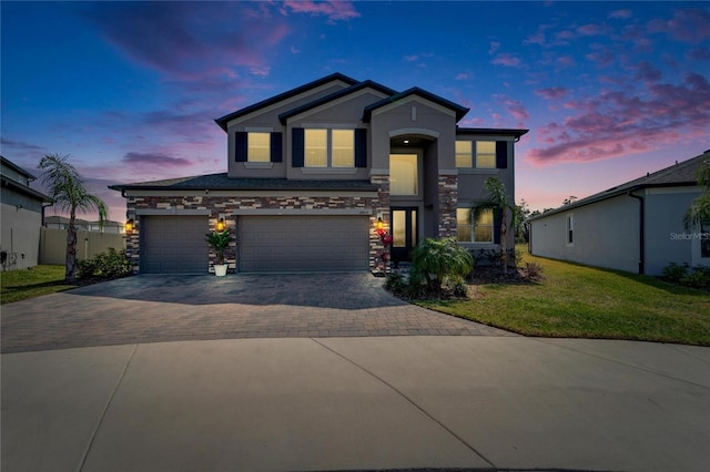 view of front of property with stucco siding, a front lawn, decorative driveway, stone siding, and an attached garage