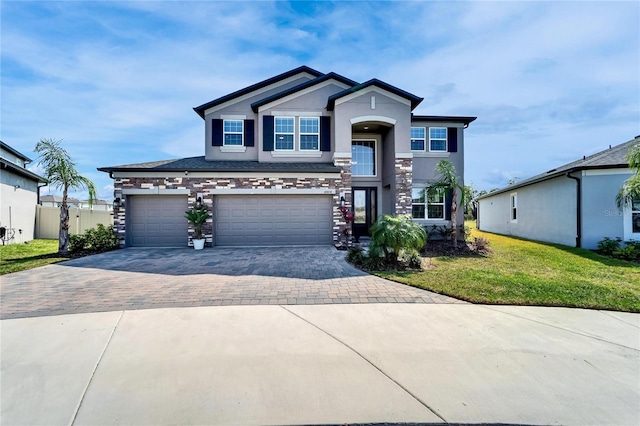 view of front facade with stucco siding, an attached garage, decorative driveway, and a front lawn