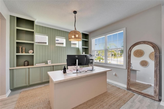 office area featuring light wood finished floors, arched walkways, a textured ceiling, and baseboards