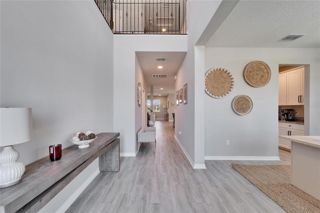 entryway featuring visible vents, baseboards, and light wood-style floors