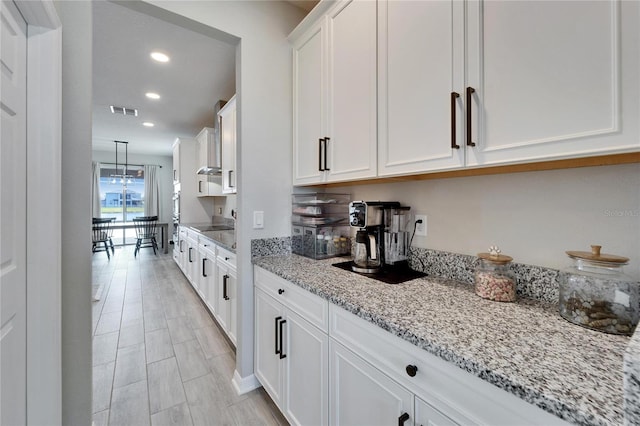 kitchen with visible vents, black electric stovetop, light stone countertops, recessed lighting, and white cabinets